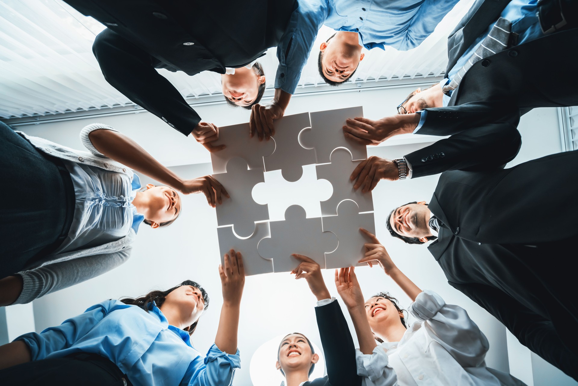 Multiethnic business people holding jigsaw pieces together. Habiliment Multiethnic business people holding jigsaw pieces together. Habiliment